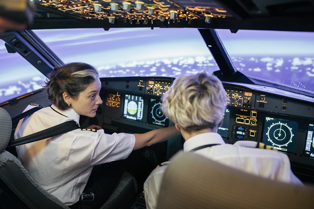 Two pilots using a flight simulator