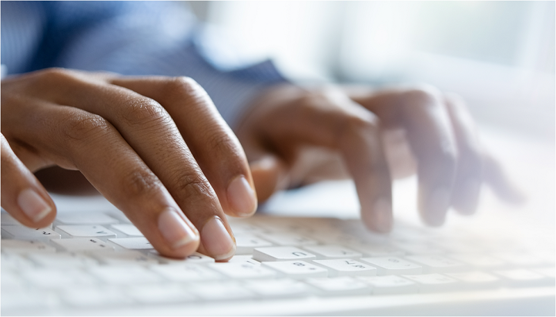 Two hands typing on a keyboard